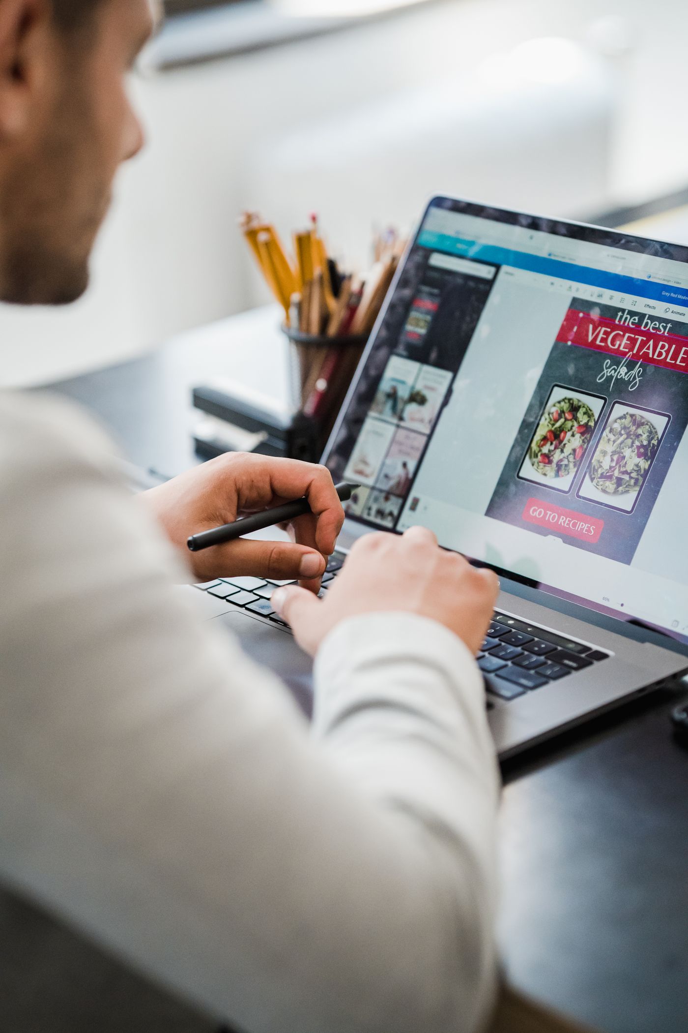 Designer care lucrează la laptop într-un spațiu de lucru luminos